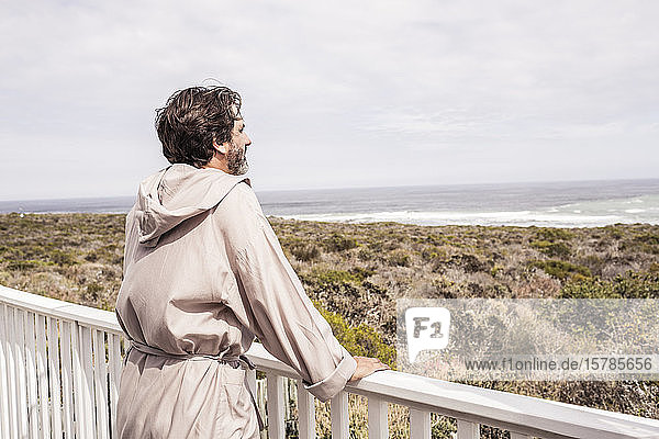 Man wearing bathrobe and enjoying view at distance on a terrace