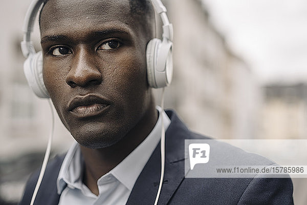 Porträt eines jungen Geschäftsmannes mit weißen Kopfhörern