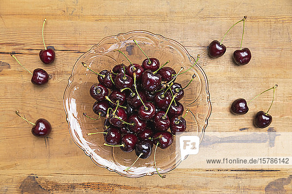Cherries in glass bowl on wooden table