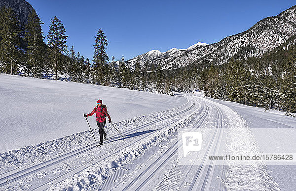 Senior woman doing cross-country skiing with karwendal mountains in background  Bavaria  Germany