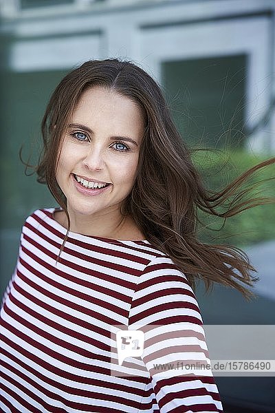 Porträt einer glücklichen brünetten Frau in der Stadt