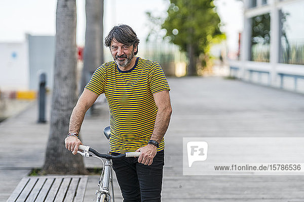 Portrait of smiling mature man with bicycle  Alicante  Spain