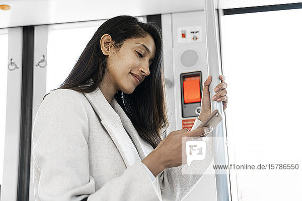 Young woman using smartphone in a tram