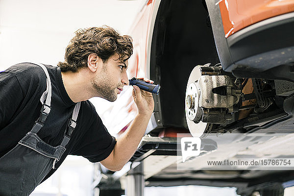 Automechaniker in einer Werkstatt bei der Arbeit am Auto
