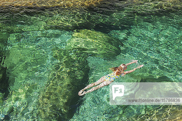 Woman swimming in refreshing Verszasca river