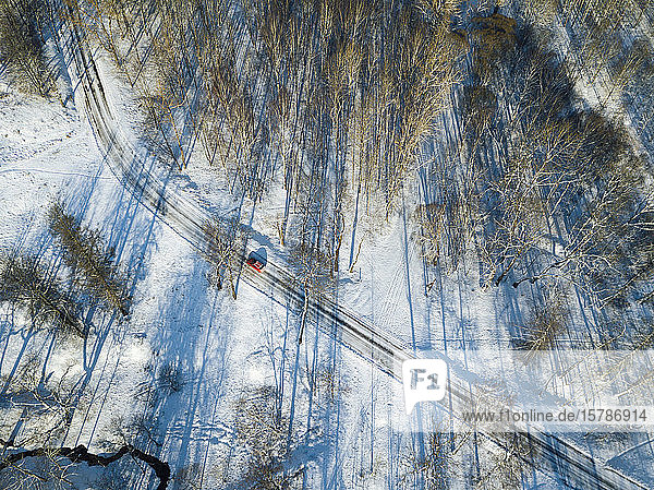 Russland  Sankt Petersburg  Luftaufnahme eines Autos  das auf einer schneebedeckten Landstraße fährt