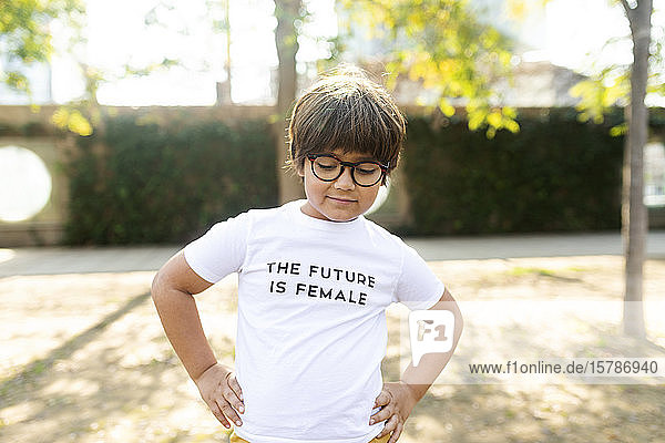 Stolzer kleiner Junge steht auf der Straße mit einem Aufdruck auf einem T-Shirt und sagt  die Zukunft sei weiblich