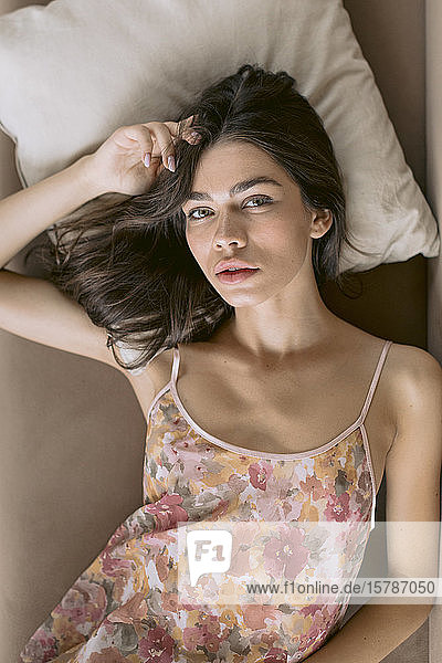 Porträt einer schönen jungen Frau im Bett liegend