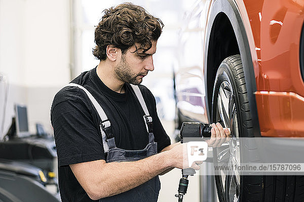 Automechaniker in einer Werkstatt beim Reifenwechsel