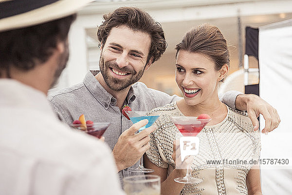 Couple and friend socializing on a cocktail party