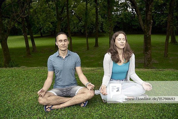 Couple doing yoga in park. Munich  Germany.
