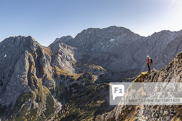 Mountaineer with climbing helmet stands on a rocky outcrop  hiking trail to the Ehrwalder Sonnenspitze  Ehrwald  Mieminger Kette  Tyrol  Austria  Europe