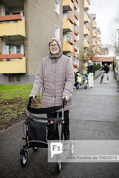 Seniorin mit Rollator vor einem Wohnhaus für Senioren  Köln  Nordrhein-Westfalen  Deutschland  Europa