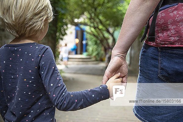 Mutter hält ihre Tochter an der Hand und bringt sie in den Kindergarten  Köln  Nordrhein-Westfalen  Deutschland  Europa
