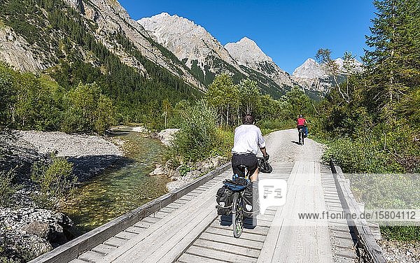 Radfahrer  Mountainbiker radeln auf Brücke über Bergbach  Schotterweg zum Karwendelhaus  Karwendeltal  Tirol  Österreich  Europa