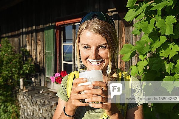 Junge Wanderin trinkt Buttermilch auf der Kraftalm  Hohe Salve  Itter  Kitzbüheler Alpen  Tirol  Österreich  Europa