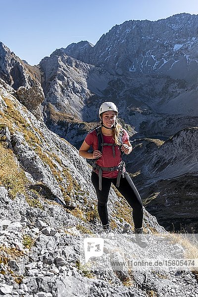 Mountaineer  young woman with climbing helmet hiking on a steep rocky slope  hiking trail to Ehrwalder Sonnenspitze  Ehrwald  Mieminger Kette  Tyrol  Austria  Europe