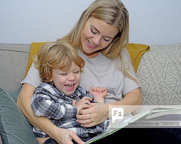 Mutter liest ein Buch mit einem Jungen  der Spaß hat  Schonen  Schweden  Europa