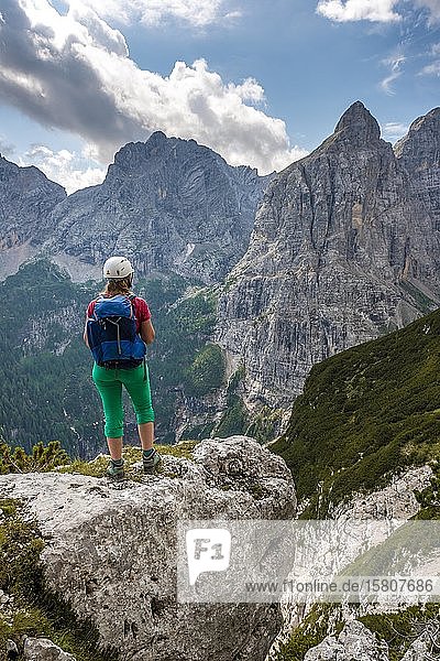 Junger Wanderer mit Helm und Blick auf die Berge  Sorapiss Rundweg  rechts der Berg Corno Del Doge  Dolomiten  Belluno  Italien  Europa