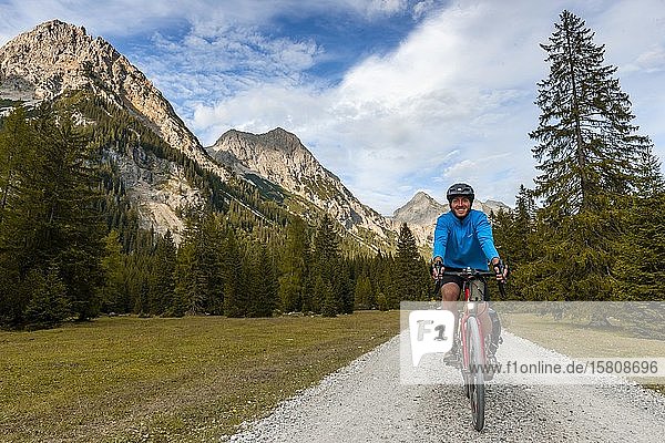 Radfahrer  Mountainbiker fährt auf Schotterstraße  Karwendeltal  Weg zum Karwendelhaus  Tirol  Österreich  Europa