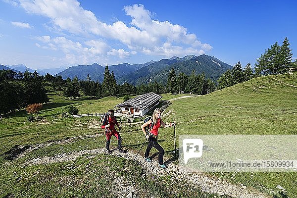 Hikers in front of the Oberauerbrunstalm  Schleching  Chiemgau  Upper Bavaria  Bavaria  Germany  Europe