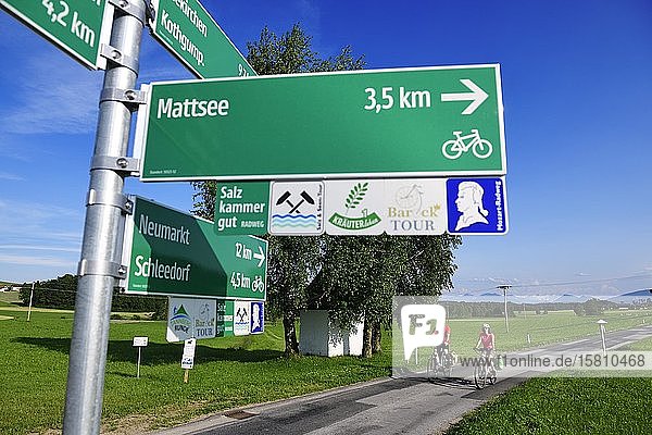 Couple with electric bikes in front of cycle path signs Schleedorf Salzburger Seenland Salzburger Land Austria Europe