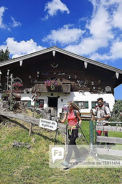 Hikers in front of the Chiemhauser Alm Schleching Chiemgau Upper Bavaria Bavaria Germany Europe