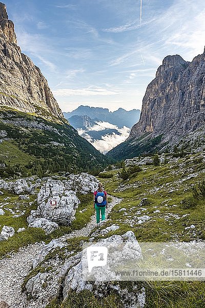 Young hiker on a hiking trail  Sorapiss roundabout  on the right Corno Del Doge mountain  Dolomites  Belluno  Italy  Europe