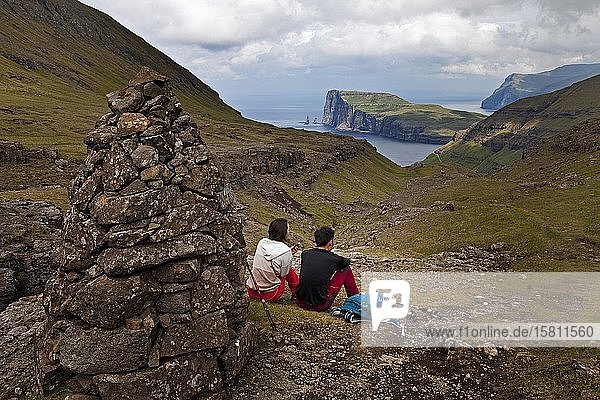 Two hikers taking a break with a view of the Atlantic Ocean  hiking trail from Tjørnuvík to Saksun  Streymoy  Faroe Islands  Føroyar  Denmark  Europe