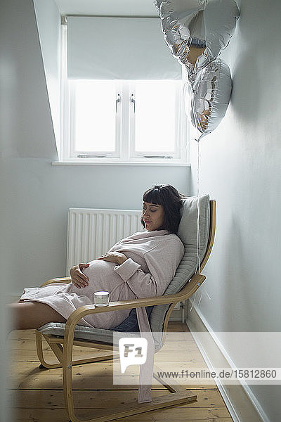 Gelassene schwangere Frau im Bademantel beim Entspannen