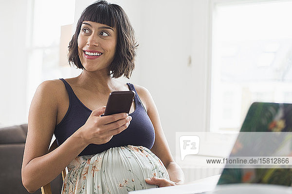 Glückliche schwangere Frau mit Smartphone