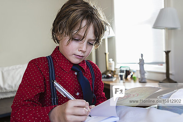 A six year old boy drawing on sketch pad