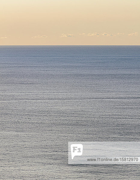 Blick auf ruhiges Ozeanwasser  Horizont und Himmel in der Morgendämmerung