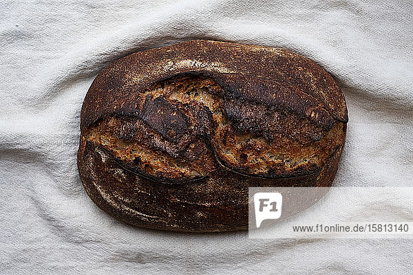 Hochauflösende Nahaufnahme eines frisch gebackenen Brotlaibs in einer handwerklichen Bäckerei.