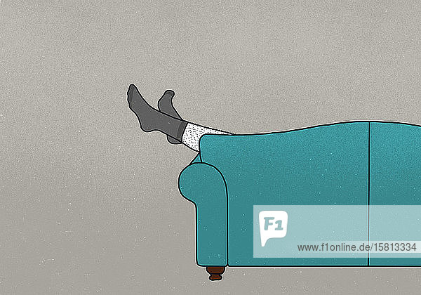 Beine eines Mannes in Socken baumeln vom Sofa