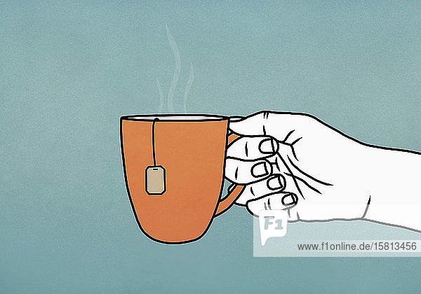 Hand hält Becher mit heißem Tee