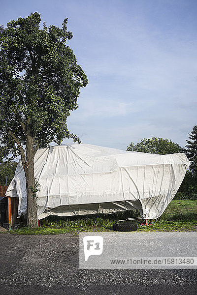 Covered boat in sunny backyard