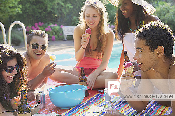 Freunde im Teenageralter genießen Bier und Eis am Sommerpool