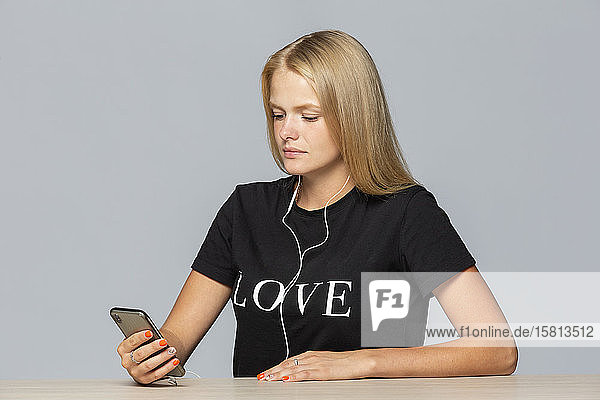 Junge Frau im verliebten T-Shirt beim Musikhören mit mp3-Player und Kopfhörern