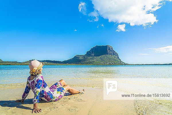 Frau in hellem Kleid entspannt am tropischen Strand  La Gaulette  Le Morne Brabant  Mauritius  Indischer Ozean  Afrika