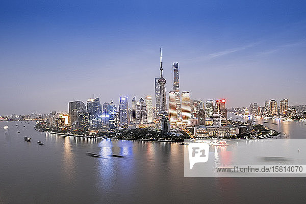 Die beleuchtete Skyline des Bezirks Pudong in Shanghai mit dem Huangpu-Fluss im Vordergrund  Shanghai  China  Asien