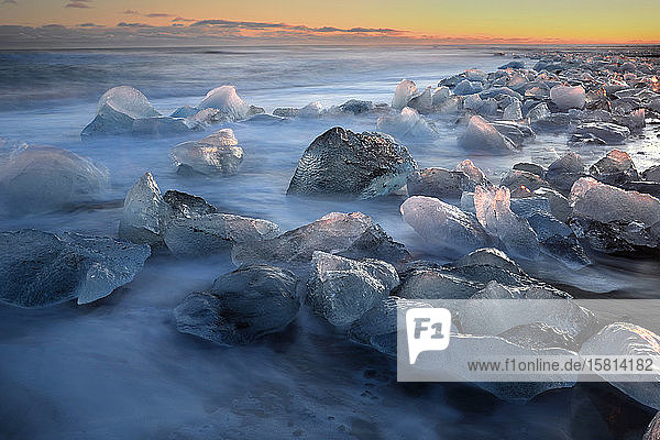 Gletschereisstücke auf schwarzem Sand  die von den Wellen umspült werden  Island  Polarregionen