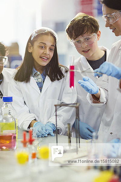 Neugierige Schüler führen ein wissenschaftliches Experiment durch und beobachten eine Flüssigkeit in einem Fläschchen in einem Laborklassenzimmer
