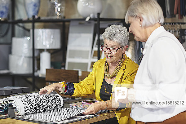 Ältere Frauen betrachten Stoffmuster in einem Geschäft für Wohnkultur