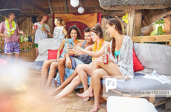 Junge Freunde hängen ab  trinken und machen ein Selfie am Sommerpool