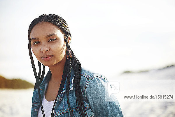 Porträt selbstbewusste junge Frau am Strand
