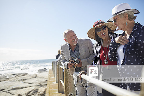 Active senior tourist friends at sunny ocean overlook