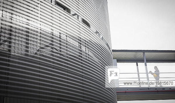Female supervisor walking on elevated walkway connected to building