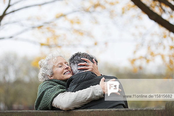 Affectionate  tender senior couple hugging in autumn park