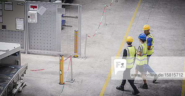 Workers walking and talking in factory